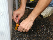 Securing the greenhouse shade cloth to a ground stake