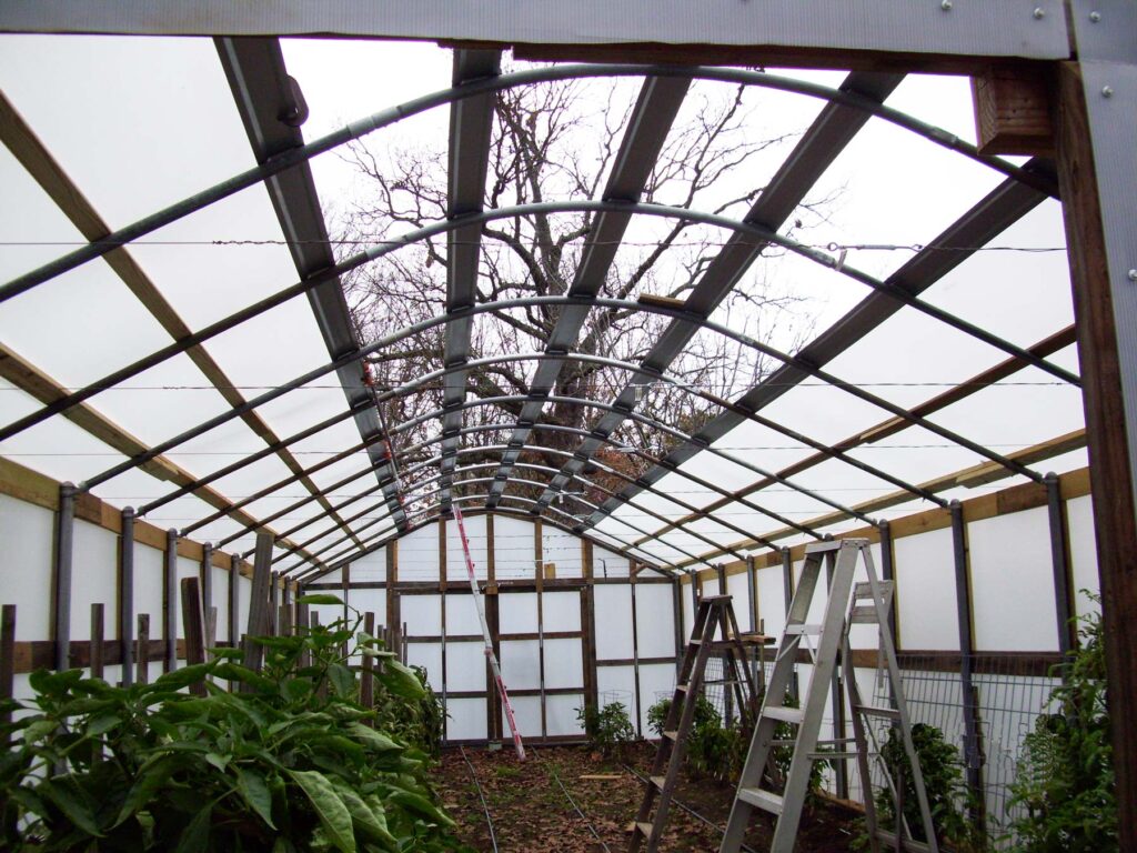 Inside the high tunnel greenhouse as the Solexx covering in being installed.